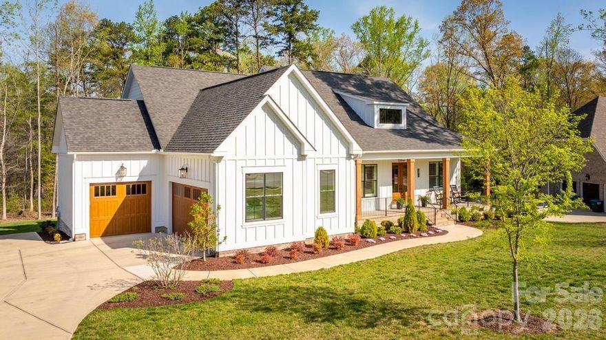 Better than new in Irish Creek, this beautifully crafted modern farmhouse radiates Southern charm! This custom single-level home offers 3 bedrooms, 2.5 baths, and a spacious 3-car garage, perfectly positioned on a private, wooded homesite. Designed for both everyday living and effortless entertaining, the open-concept floor plan features soaring ceilings, abundant natural light, and a dramatic wall of windows framing serene backyard views. The great room and dining area are enhanced by elegant coffered ceilings, adding architectural interest and warmth throughout. Step into the stunning screened porch through expansive bi-fold doors, creating a seamless indoor-outdoor connection. This inviting outdoor retreat features a vaulted ceiling and a floor-to-ceiling stone gas fireplace—ideal for year-round enjoyment. An adjacent deck provides the perfect space for grilling or relaxing in a peaceful, wooded setting. The gourmet kitchen is a chef’s dream, featuring a gas cooktop with pot filler, an oversized island with additional storage, and a generous walk-in pantry with custom wood shelving.
A thoughtfully designed split-bedroom layout offers privacy, with the luxurious primary suite tucked away on one side of the home and secondary bedrooms on the opposite wing. Additional upgrades include plantation shutters and custom window shades, an epoxy-finished 3-car garage, hardwood floors throughout the primary living areas, and extensive crown molding. Located in the highly sought-after Irish Creek community, residents enjoy Social Membership to The Club at Irish Creek, including access to the swimming pool and dining amenities, with additional club offerings available. Conveniently situated just minutes from I-85, shopping, dining, and Concord-Padgett Regional Airport, this home offers the perfect blend of privacy, luxury, and accessibility.