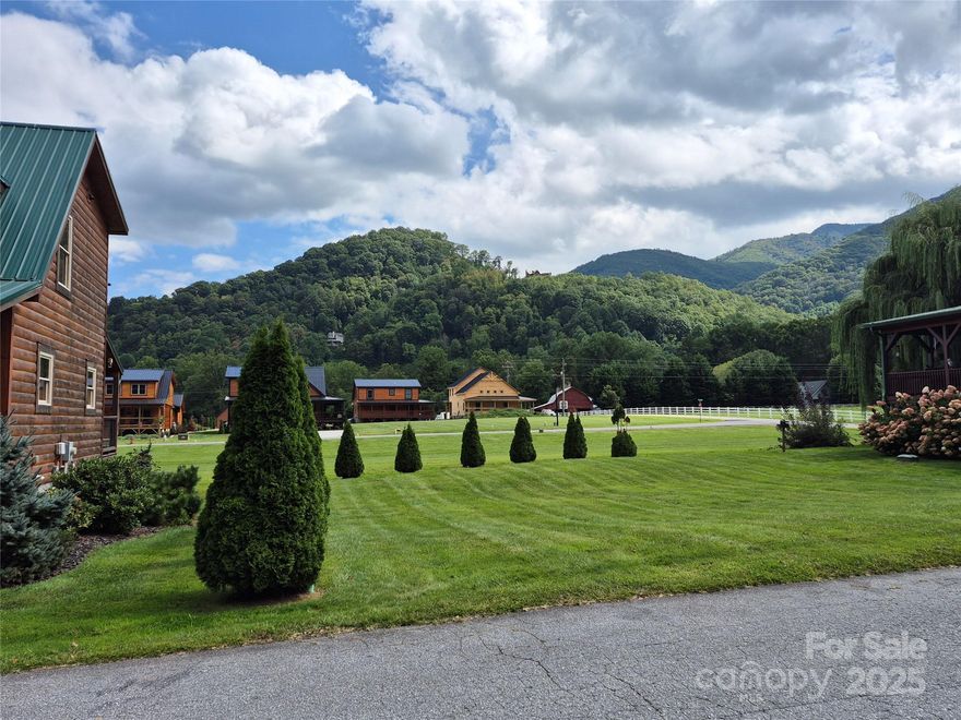 Great flat building lot in Crocketts Meadow! This is a highly desired neighborhood close in to the heart of Maggie Valley and consists of Log Homes and wood-sided homes, all with metal roofing. Very well kept community with underground utilities, paved roads, city water, city sewer, and high speed internet available! Plus the POA mows all the yards. Very few vacant lots are left in this prime neighborhood sitting at 3000+ feet elevation on the upper end of Maggie Valley. Live here and you'll enjoy nice mountain scenery and mountain views all year round. This property is not in a flood zone and offers super-easy year round access. Why wait, come build your dream cabin on this prime lot, or buy now and build later.