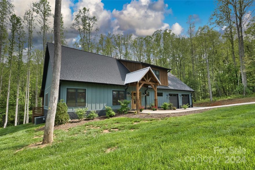 This custom home comes fully furnished - just bring your toothbrush! Just 2 miles to downtown Hendersonville and 35 minutes to Asheville's vibrant core. A light-filled, welcoming interior opens to a spacious living area, perfect for entertaining. Luxury finishes abound, including stunning leathered granite countertops in the kitchen. Primary suite on main floor offers privacy from the additional bedrooms and den/flex space upstairs. This successful STR seamlessly utilizes the tranquil outdoors. A large open deck overlooks a fire pit,hot tub, and a meandering stream, creating a truly relaxing environment. The thoughtful design allows owners to enjoy the home themselves while also functioning well for renters. The extra-deep garage accommodates up to three cars with additional storage space. An RV pad on the exterior boasts electrical hookups and a clean-out, making it ideal for RV enthusiasts. Enjoy the convenience of being within walking distance of the Ecusta Trail!