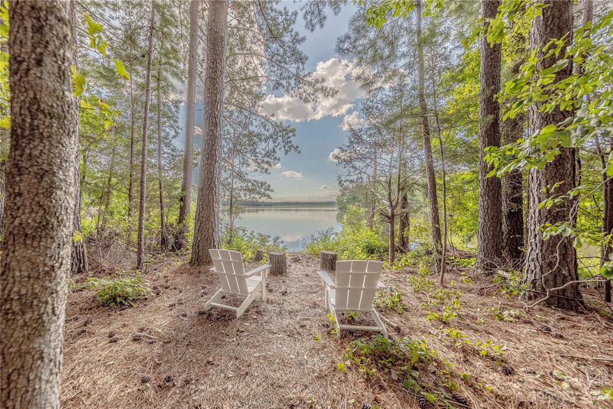 Prepare to fall in love with this remarkable 7+ acre lot along the shore of Bear Creek.  Located at the end of a private driveway, this unique parcel will take your breath away with its sweeping 180 degree views of the water and remarkable west facing sunsets over the dam.  With no restrictions or covenants this property is perfect for both immediate recreational enjoyment or future dream home construction.  Unlike other bodies of water that can accommodate motorized boats, no unique permit restrictions limit construction of docks.  Presently featuring a storage building, a wired storage building and an unfinished off-grid cabin (all of which convey with acceptable offer) complete with solar array, tankless water heater, water capture of filtration system and plans for completion, this is the rare opportunity to privately own some of the best natural beauty available.