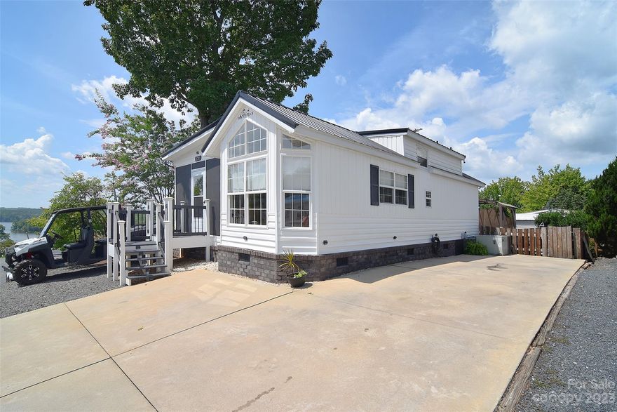 Experience the epitome of lakeside living with this magnificent 1-bedroom park model home in Badin Shores Resort at Badin Lake. Beyond its charming facade, this home boasts a unique sleeping loft that adds a touch of versatility to its layout. The large screen porch beckons you to embrace the outdoors while staying comfortably sheltered. Step into your own private fenced oasis in the backyard, with a pergola that invites relaxation, and a separate building designed as a hangout space for your entertainment desires. The interior exudes modern elegance, showcasing stainless steel appliances that combine functionality with style. The upgraded washer and dryer enhance convenience, while shiplap accents add a touch of charm. Ample parking ensures that your guests feel as welcomed as you do. Set against the backdrop of a water view, this property encapsulates the perfect blend of comfort, luxury, and natural beauty, making it a dream come true for those seeking an idyllic lakeside retreat.
