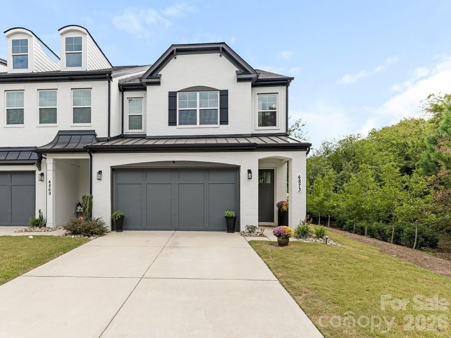 Experience elevated living in this stunning two-story end-unit townhome, designed for those who value privacy, light, and modern luxury. Set on one of the community’s most desirable lots, the home features a fenced backyard, adjacent green space, and an abundance of natural light throughout. Located in the heart of South Charlotte, it delivers the perfect balance of upscale design and effortless functionality.

Wide-plank luxury vinyl flooring flows seamlessly across both levels, creating a warm, sophisticated backdrop. The main level boasts a spacious primary suite and an open-concept layout ideal for both unwinding after work and hosting weekend gatherings. The chef-inspired kitchen showcases a generous island, sleek modern cabinetry, and a seamless connection to the living and dining areas. A dedicated laundry room and stylish drop zone sit just inside the attached two-car garage for everyday ease.

Upstairs, a versatile loft with custom built-ins and a beverage cooler offers the perfect flex space—ideal for a home office, media lounge, or creative retreat. The upper level also includes a second primary suite with a private ensuite bath, along with two generously sized bedrooms that share access to a well-appointed jack-and-jill bathroom.

Minutes from Carmel Commons, SouthPark, Carmel Country Club, Quail Hollow Country Club, and quick access to I-485, this home places you close to the area’s best shopping, dining, and entertainment. With thoughtful upgrades, premium finishes, and a prime location, this townhome delivers a refined lifestyle tailored for modern professionals.