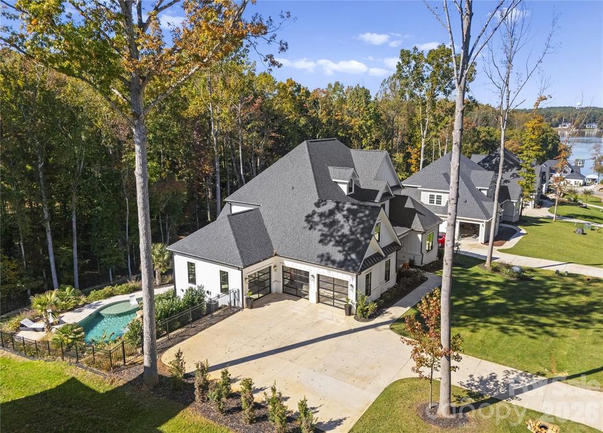 Meticulously designed home with thoughtful details inside and out. Slide into summer in your stunning pool complete with hot tub, tanning ledge & dual sheer descent waterfalls. Catch the games on the covered entertainment patio with Travertine tiled floors overlooking the fenced backyard & Koi pond. A two-story great room with gas fireplace offers bifold doors leading to a gorgeous, screened porch for seamless entertaining. The magazine worthy kitchen offers a large island, quartz counters & backsplash, walk-in pantry, gas range, vent hood & pot filler over stove. The main level Primary suite features an expansive vanity, 11x5 shower with digital controls & a gorgeous custom closet. The private junior suite on the second level offers a bedroom, bonus room full bath & custom closet. The basement is loaded with goodies! Entertaining bar w/Labradorite counters, beverage fridge and dishwasher. Media space with built in speakers for theater sound. Fitness room with TV outlet on wall. Private office with built-in cabinets & desk. A safe room to safely store all of your valuables and a rec room designed for a golf simulator. There is also a flex room with a full bath accessible to the outside. A 3-car garage w/glass doors & workshop top off this lovely home which also features full irrigation and a whole house Culligan water filtration and softener system.