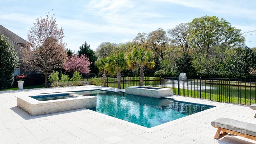 CHATELAINE... Gated Community... Resort Style Living... Luxury Estate w/Outdoor Oasis! Primary Suite + Guest/Flex Suite on Main! 3 Fireplaces, 5 Bedrooms, 5 Full Baths, 2 Half baths, Bonus Room + Media Room! Stunning Backyard Overlooks... Scenic Waterfall, NEW Pool w/Spa & Limestone Decking that Stays Cool in the Heat (2019), NEW Outdoor Kitchen (2019) w/Stainless Appliances, Huge Covered Veranda w/Fireplace & Custom Retractable Screens (2019)! Family Room w/Coffered Ceiling, Built-Ins, Fireplace & Sliding Doors to Porch & Pool! Formal Dining & Dream Kitchen w/SubZero Refrigerator, Gas Cooktop w/Custom Hood, Storage, Walk-In Pantry, Island w/Counter Seating, Cozy Keeping Room w/Stone Fireplace & Built-In Window Seats overlooking pool. Upstairs 3 Bedrooms w/Private Baths, Large Bonus w/Wet Bar, Half Bath & Media Room! Walk-in Attic, 3-Car Garage, Rear Entry Drop Zone, Laundry Room w/Built-Ins. NEW ROOF (2024). Pristine! Close to Shopping & Dining. Prized Weddington Schools...Wow!!!