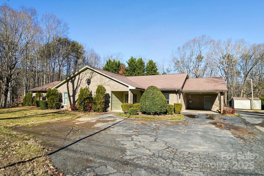 Here's your chance to own a home with room for everyone. With over 3600 square feet of living space, this all brick, one level, 6 bedroom, 3-1/2 bath home is ready for new owners. Large living room with built-in cabinetry, kitchen with pantry, extra storage room, laundry room w/ sink and additional storage room under carport. The screened in back porch is perfect for gathering with friends and family. There's also a storage building with two additional covered areas and a basement that's perfect for a small workshop, canning cellar or hobby area. Freshly painted interior, new primary bathroom dual vanity, all new carpet and new solid flooring in some areas. This home is perfect for people who require the use of a wheelchair as it is accessible from exterior as well as throughout the home. No city taxes or HOA. Private Road. Photos are virtually staged to show space and potential layout.