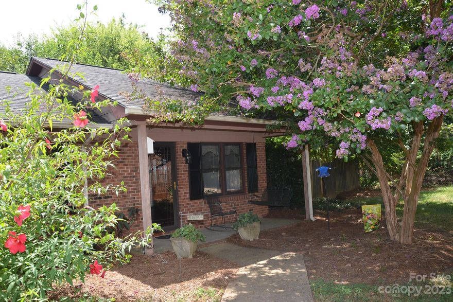 Charming END UNIT tucked in the back of a peaceful neighborhood.  NO STEPS to the unit.  Very few multi-family residences have yards and green space readily accessible like this one.  Roomy kitchen with white cabinets and a laundry closet with Washer and Dryer included!   Refrigerator and microwave are included too.  Ample Family Room with area for a dining table. Backyard and side yard are fully fenced and overlook wooded area.  Lots of privacy in the side yard beside the unit.  Covered front porch that is shaded all day long and unit is tucked away on the end for added privacy.  Cozy Sunroom and storage closet on the back of the home. AC has a semi-annual service contract and records can be provided upon request. Newer Water Heater.  Lots of closets for a unit this size!  Units don't come up very often in this neighborhood- don't miss this one!