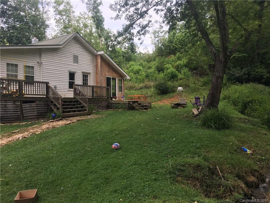 Country cottage on semiprivate lot being sold "AS IS". Home has been completely updated with an additional bed and bath added (Permits were not obtained). No septic record on file. Running stream, room for chickens, outbuilding and acreage all make this suitable for country living. Hardwood flooring, wood stove, spacious master bedroom/bath, heat pump approx. 1 year old, not too far from 26 but in Yancey County. Peaceful setting but yet close to conveniences.