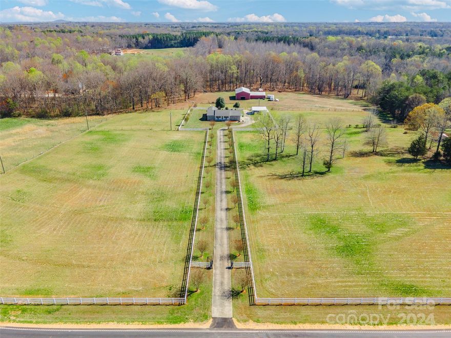 Nestled on 30 acres of breathtaking land, this property offers tranquility & charm. Relax on the covered front rocking chair porch & admire the scenic views. Inside, hardwood floors adorn the main living areas, creating an open, bright atmosphere. The great room boasts a stone fireplace & elegant chair railing that extends into the dining area. The spacious kitchen features an island/breakfast bar, double oven, tile backsplash, with bay windows in the breakfast area providing a stunning view of the land & barn. With 3 spacious bedrooms & 3 full baths, including a primary bath w/ a garden tub & separate shower, comfort is ensured. Step onto the cozy screened, tiled back porch & soak in the serenity of the expansive property. A barn with 2 horse stalls, a workshop, tractor storage, & pasture awaits, ideal for horses, cows, or goats. Additional features include a chicken coop, fenced pasture and beautiful rows of crepe myrtles along the driveway. Located in the desired Clover area!