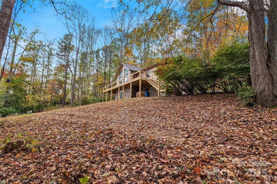 Discover your dream Asheville lifestyle in this beautifully renovated contemporary home, nestled within the highly sought-after Pioneer Trails community. Perfectly positioned in the desirable Bee Ridge/Avondale area, this property offers unparalleled convenience – just 10 minutes from vibrant downtown Asheville, moments from the scenic Blue Ridge Parkway, and mere minutes to major shopping, dining, and essential amenities. Enjoy the best of both worlds with a prime location just outside city limits, benefiting from lower county taxes. Situated on a generous 1.01-acre private lot, the mostly wooded surroundings provide a serene escape with lovely winter mountain views. Outdoor living shines with a huge, brand-new full-length open front deck perfect for entertaining, complemented by a large 19' x 20' covered rear porch ideal for relaxing family meals or offering future screening or expansion possibilities. Step inside to find a home transformed by extensive recent renovations, leaving nothing left to do but move in. Updates include fresh exterior paint, a new architectural roof, the stunning new front deck, a newer heat pump/AC system, durable new vinyl plank flooring throughout, fresh interior paint, and new vinyl insulated windows. The heart of the home is the completely new kitchen, boasting stainless steel appliances, gleaming granite countertops, and a convenient eat-in bar. Further enhancements include a new side deck, stylish new light fixtures, new interior and exterior doors, new garage doors, beautifully updated bathrooms, and a new whole-house water filtration system. Cathedral ceilings soar over the open living and dining areas, bathing the space in natural light that extends seamlessly onto the large covered rear porch. A massive stone woodburning fireplace anchors the living room, creating an inviting and cozy atmosphere perfect for mountain evenings. The thoughtful split-bedroom design features three bedrooms and two full baths, ensuring privacy. The large primary suite opens directly onto the new front deck, plus offers a spacious walk-in closet with a custom barn door and a private en-suite bath. Conveniently located off the kitchen, the main level laundry room also serves as a large walk-in pantry and leads out to the new open side deck. Adding fantastic versatility, the daylight basement offers an additional 635 sq ft of finished, heated space featuring a family room and a full bath, presenting excellent potential for a media room, home office, or guest suite (this space was finished without permits, not counted in total square footage). The large two-car basement garage provides ample storage with tandem parking possibilities on one side, while the other side is best suited for a compact vehicle. Don't miss this opportunity to embrace a fully updated, private retreat offering exceptional convenience and modern comfort, ready for you to start creating lasting memories.