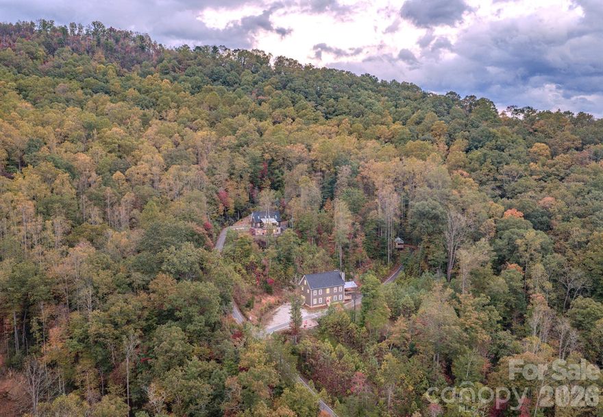 Mountain Multi-Home Blue Ridge Retreat located just under the Parkway about 45 minutes to Asheville. (includes address 8032 Buck Creek- ability to purchase separately) Rare chance to owna high-capacity, income-producing retreat bordering Pisgah National Forest. This secluded paradise surrounded by pristine views (not a home in site)- offers 14 BR / 14.5 BA spanning four fully furnished structures (Main House, Summit House, and two themed tiny guest quarters) with luxury finishes, hot tub, paved access and paved drives throughout the property with sweeping panoramic mountain views. Scenic easy drive to the property along Buck Creek and less than 2 miles from Parkway access (when reopen). The Main House (6 BR each with an ensuite full bath) features Bertazzoni appliances, Two commercial refrigerators, gas stoves, chimneys in place-to add fireplace, king suites, and modern living areas. The Summit House (6 BR each with its own bath) includes a hot tub, workout room, private decks, and spectacular mountain views. Two custom tiny homes add unique lodging appeal and expansion potential for more themed miro lodging. With proven short term rental demand this is Ideal for STR investors, retreat operators (yoga, church groups, car clubs, wellness, outdoor enthusiasts) or just a large family mountain getaway. The MLS does not allow for all the photos. Properties can be purchased separately as well. 
This turnkey retreat balances seclusion with accessibility, offering unmatched capacity and income potential in the Blue Ridge Mountains near Mount Mitchell. Square foot measurements are a total of all structures. 
Cross posted MLS # 4342783