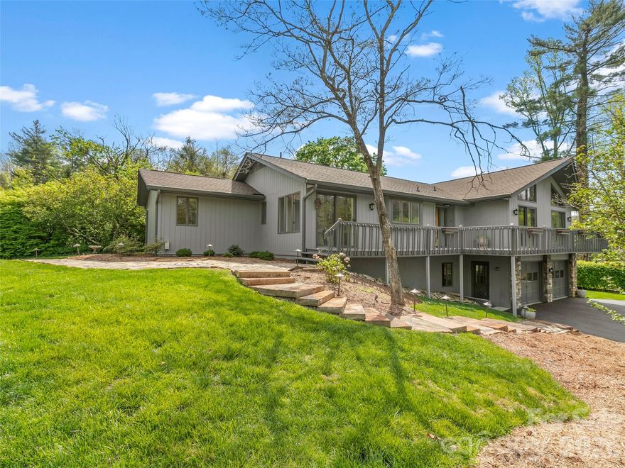 Perfectly positioned in the desirable Sycamore Hill neighborhood just off Haywood Road, this exceptional residence offers refined living only minutes from downtown, the airport, and I26. Hickory hardwood floors grace the main living areas, leading into a beautifully updated kitchen featuring granite countertops and a striking mosaic tile backsplash. The spa-inspired primary bath is a true retreat, showcasing granite countertops with a waterfall edge, heated marble floors, and dual walk-in closets. The primary suite is further enhanced by a private sunroom—an inviting space to relax and enjoy year-round comfort. The living room offers an elegant yet welcoming atmosphere, ideal for both intimate gatherings and entertaining. The lower level provides exceptional versatility with a guest bedroom and bath, a dedicated office, and generous space for a workshop or additional storage. Outside, the home continues to impress with fresh exterior paint, curated landscaping, and a charming flagstone walkway with stone steps leading up from the driveway. Enjoy close-range mountain views that add to the home’s serene setting.