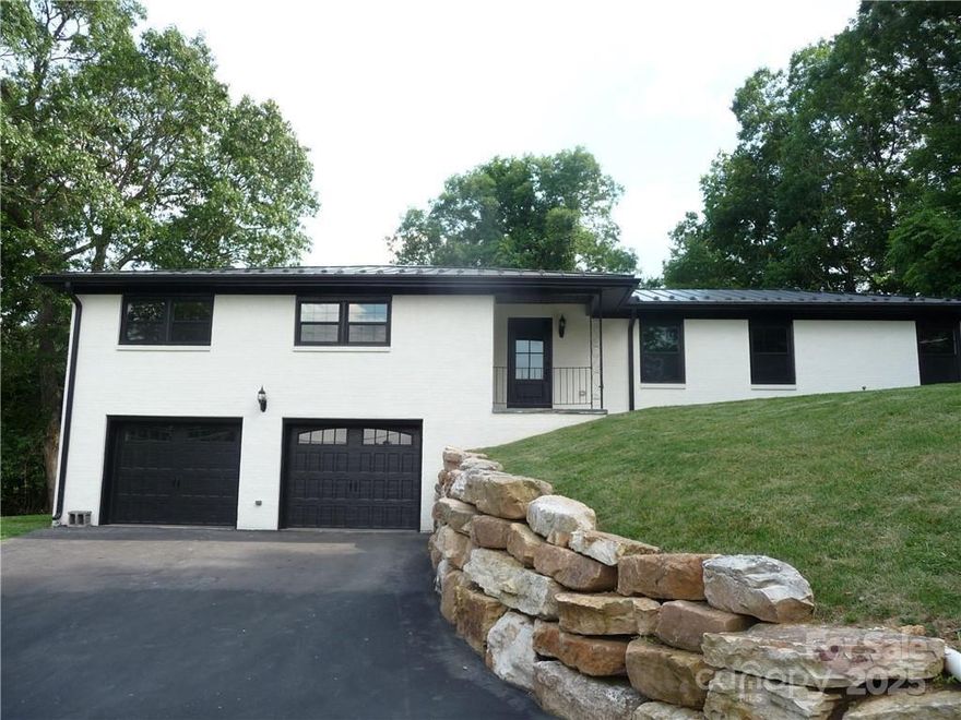 This stylish Ranch Home is full of pleasant surprises from the moment you enter the foyer with it’s decorative accent wall and stained glass ceiling light. The floor plan flows into the formal living room which leads to a formal dining room with wainscoting and chandelier. This flows directly to the open kitchen with farmhouse sink, subway tiles, new stainless appliances, an island provides additional seating and prep space, large pantry, and informal dining area open to informal living/family room with brick fireplace. LVP flooring through-out main rooms, crown molding through-out all rooms, smart features, recessed lighting, and plenty of natural light. The wainscoted Hall has additional closets providing extra storage. The main bath features double vanity, shower/tub, and impressive tile work. The primary suite features double closets and bath with double vanity and large tiled walk-in shower. All three bedrooms have ceiling fans and lighted closets. Oversized 2-car garage opens to heated basement that is ready to finish to your taste. An outbuilding in the backyard has electric available and with repairs could become a spacious workshop/studio. This home is located near Watauga High School, and minutes to ASU and downtown Boone. The scenic New River and Greenway Walking Trail are nearby.