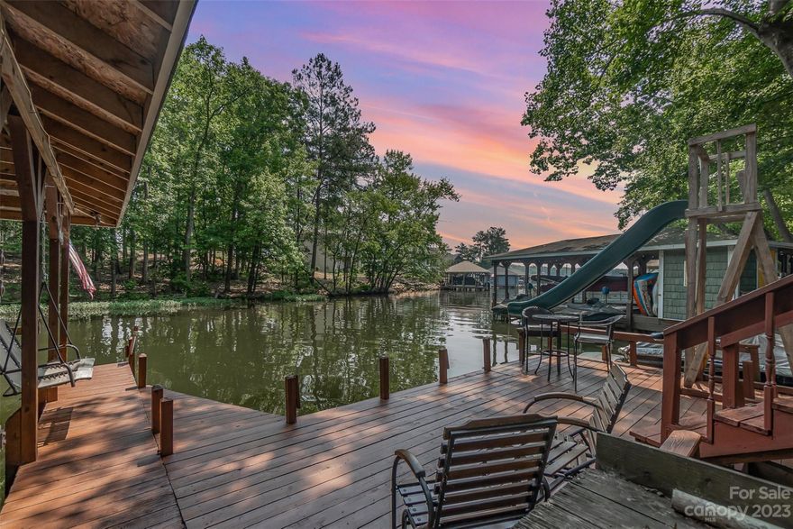 Tranquil retreat on a quiet cove with deep water! This charming waterfront lake house has so much to offer!  Gorgeous 2-slip boathouse with lifts, storage, new jet ski dock, and new retaining wall! Nice open sundeck recently replaced! Great for fishing, sunbathing or watching people enjoy the slide!  Lighted steps to dock from house. Open floor plan on main level gives a cozy ambiance in this bungalow! New kitchen remodel with granite, new stove/dishwasher, new glass windows in dining area which opens up to the living area. Two bedrooms and a bathroom complete the main. Downstairs has a second family room with gas fireplace and large enough for couches, bunk bed and air hockey table! But that's not all!! Two bonus rooms, new full bathroom, new laminate wood floors and new sliders out to patio. There is room for everyone! Large deck off the patio with fire pit for cool evenings or enjoy bug free screen porch in serene surroundings at Lake Tillery! It's the one you've been waiting for!