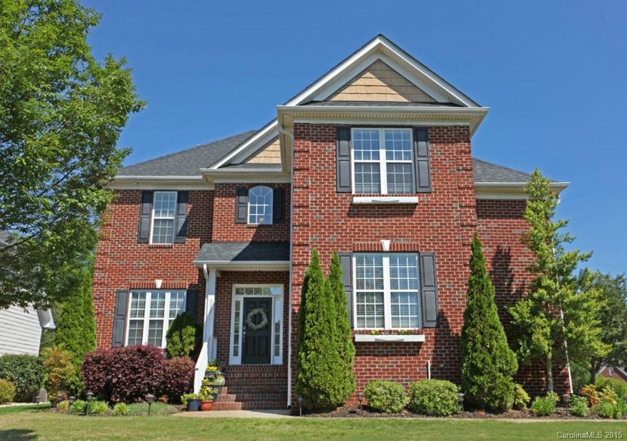 Absolutely Stunning Brick Home in amenity rich community! Curb appeal & inside awe from the manicured, easy to maintain lawn to the graceful interior hardwoods throughout main. Dining rm w/ tray ceiling & wainscoting, GOURMET Kitchen w/gas cooktop, work island, granite, rich cabinetry w/ample drawers. Sunlit Brkfst Area. Elegant Master w/ tray ceiling, vaulted sitting area, garden tub and his & her sinks. Wood blinds, invisible fence, & more!  Minutes from Charlotte & award winning FM Schools!