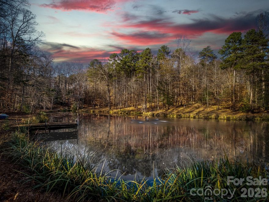 A rare opportunity awaits to own this gated 26-acre estate, seven springs on Lake Norman, complete with a private boat dock. The property showcases exceptional features, including a 2-acre spring-fed pond, a spacious 1,678 sq. ft. detached garage/workshop adaptable for multiple uses, former horse stalls, and a charming potting shed or she-shed. Ideally situated just outside the Long Island Airport strip, this remarkable estate offers endless possibilities and areas to explore. Additional amenities include state-of-the-art surround sound, a whole-home generator, an electric vehicle charging station in the garage, fruit trees, a full home theater in the basement with a 3D projector, and solid mahogany doors throughout. The outdoor living area is truly extraordinary, featuring a resort-style saltwater pool with waterfall and spa, a built-in grill, an outdoor fireplace, and a projector with screen. Multiple tiers of outdoor entertaining spaces create an unmatched setting for gatherings and relaxation. Inside, the great room is highlighted by an exquisite mirror imported from England, adding a sophisticated and timeless touch. The home boasts multiple fireplaces, rich Brazilian hardwood floors, dual grand staircases, and elegant marble flooring. The gourmet chef’s kitchen features double ovens, a gas cooktop, and sweeping views of the property from nearly every room. This exceptional estate is truly one-of-a-kind—an unparalleled offering that must be experienced in person to be fully appreciated.