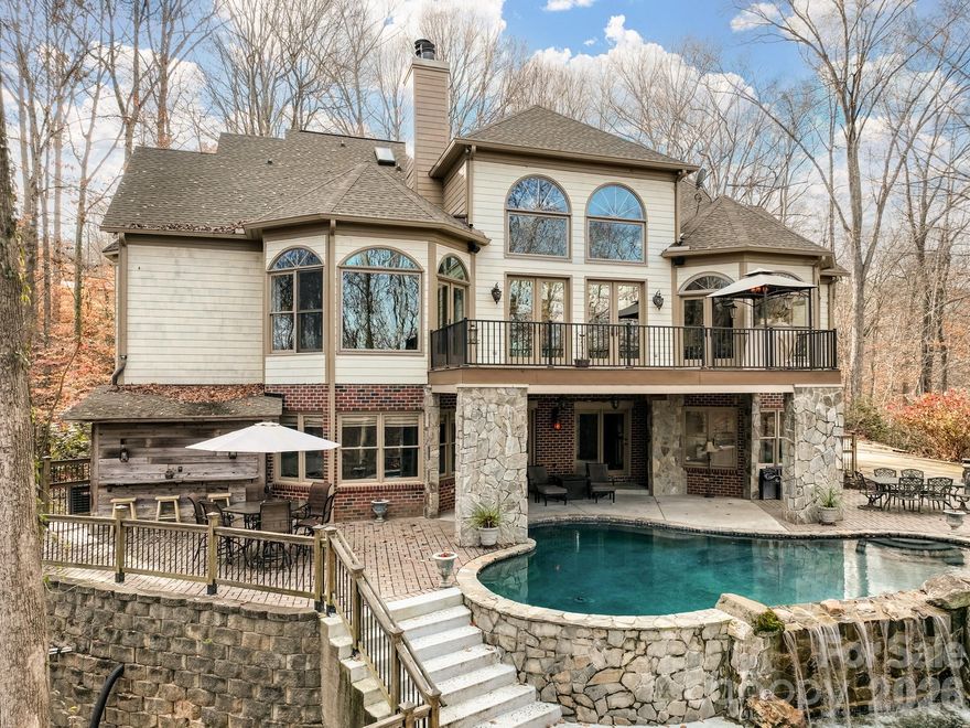 A rare opportunity awaits to own this gated 26-acre estate, seven springs on Lake Norman, complete with a private boat dock. The property showcases exceptional features, including a 2-acre spring-fed pond, a spacious 1,678 sq. ft. detached garage/workshop adaptable for multiple uses, former horse stalls, and a charming potting shed or she-shed. Ideally situated just outside the Long Island Airport strip, this remarkable estate offers endless possibilities and areas to explore. Additional amenities include state-of-the-art surround sound, a whole-home generator, an electric vehicle charging station in the garage, fruit trees, a full home theater in the basement with a 3D projector, and solid mahogany doors throughout. The outdoor living area is truly extraordinary, featuring a resort-style saltwater pool with waterfall and spa, a built-in grill, an outdoor fireplace, and a projector with screen. Multiple tiers of outdoor entertaining spaces create an unmatched setting for gatherings and relaxation. Inside, the great room is highlighted by an exquisite mirror imported from England, adding a sophisticated and timeless touch. The home boasts multiple fireplaces, rich Brazilian hardwood floors, dual grand staircases, and elegant marble flooring. The gourmet chef’s kitchen features double ovens, a gas cooktop, and sweeping views of the property from nearly every room. This exceptional estate is truly one-of-a-kind—an unparalleled offering that must be experienced in person to be fully appreciated.
