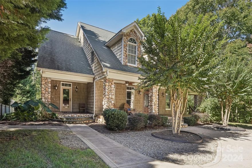 130 Hidden Harbor, a stunning waterfront estate, where luxury meets tranquility with no HOA! Step through the front door and be captivated by the open, airy layout, showcasing natural Hickory floors. The expansive great room boasts three sets of double doors leading to a deck with breathtaking lake views. The chef’s kitchen with nearly new appliances, granite countertops, and access to a screened porch overlooking the pool and lake. The peaceful main-level primary bedroom features a cozy fireplace, tray ceiling, dual walk-in closets, and private access to the deck. The luxurious ensuite bath is finished with travertine floors, an oversized steam shower, clawfoot tub & dual vanities. The upper level offers three additional bedrooms, including one with an adjoining room perfect for a nursery, playroom, or additional flex space to suit your needs.  The fully finished lower level is an entertainer's dream, with a cozy fireplace, full bathroom, bar area, flex rooms. Pool, dock and firepit!