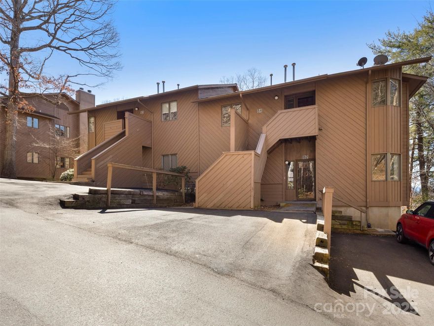 Upper-level condo with stunning mountain views in Pine Cliff Condominiums. This 2-bed, 2-bath home features fresh paint and new vinyl plank flooring throughout. Enjoy the outdoors from both a covered and open deck. The unit is wired for a satellite dish that is grandfathered into the HOA—cannot be replaced if removed. Two assigned parking spaces are conveniently located in the upper lot near the stairs. Just minutes from downtown Asheville, with easy access to shopping, dining, and more.