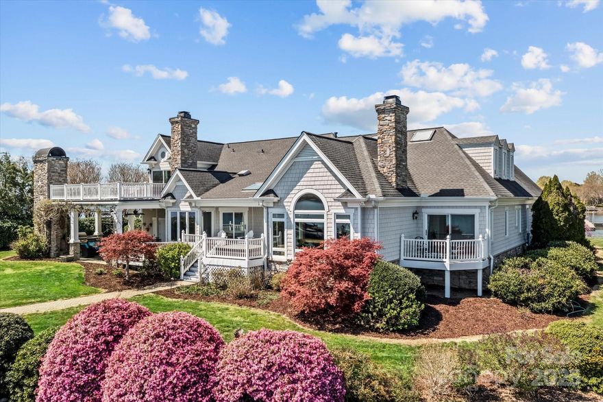 Nestled along 400+ feet of shoreline on Lake Norman, this breathtaking waterfront retreat beckons offering unparalleled blend of luxury and tranquility. On a Peninsula, surrounded by water, the private winding road leads you to  the home’s  Hardie-shake siding accented w/stone. Step inside to the open concept great room where a wall of floor-to-ceiling windows floods the space w/sunlight & frames panoramic views of the lake. The hardwood floors flow seamlessly throughout the first floor. The gourmet kitchen boasts  soft ivory custom cabinetry and granite countertops. The center island is complete w/built-in farmhouse sink & seating. Top-of-the-line stainless steel appliances, including a double oven, gas Thermador cooktop, built in refrigerator and Miele dishwasher await your culinary adventures.  The Primary suite  on the main level is a sanctuary unto itself, with dual closets. The en-suite bath featuring soaking tub (see directions)
