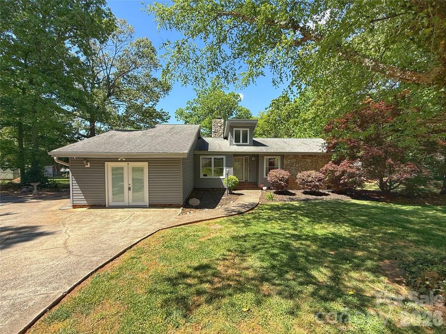 Sitting on two spacious lots in the Oakcrest subdivision and situated beside a cul-de-sac, this home offers both space and convenience. The large fenced yard provides plenty of room to enjoy the outdoors, complemented by a generous side and back deck perfect for relaxing or entertaining. The home features vinyl siding with stone accents and welcoming natural light through the foyer, creating an open feel with vaulted ceilings. The great room highlights a large stone gas fireplace as its centerpiece. The primary suite offers plenty of space with a large walk-in closet, tile shower, and soaking tub. A second bedroom and additional flex room provide great options for an office, hobby room, or guest space. An extra parking pad beside the driveway adds convenience, and two storage sheds convey with the property. Enjoy a quiet country feel while still having the benefits of a neighborhood setting.