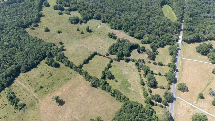 A rare and beautiful find — approximately 55.89 acres of fenced, picturesque land offering the perfect blend of rolling pasture and mature woods. With RUD zoning and an impressive 1,100 feet of road frontage, there is potential to build multiple homes, create a private estate, or establish a working farm. Serene Fishing Creek meanders along one side, adding natural beauty and a peaceful backdrop. An old barn stands as a reminder of the property’s history and charm. Whether you're envisioning horses grazing in the fields, exploring wooded trails, or simply enjoying the quiet of country life, this stunning tract offers a lifestyle that’s hard to match.