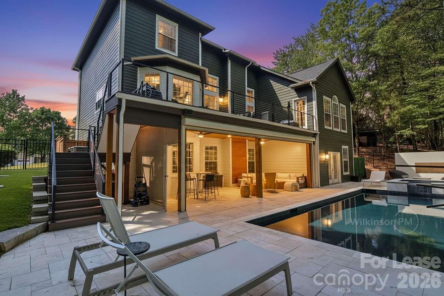 The Home: Timeless Elegance & Comfort
Tucked away on a private, wooded cul-de-sac, this completely updated, stately three-story masterpiece offers over 5,200 square feet of unparalleled luxury living. From the moment you step inside, you'll be greeted by gorgeous hardwood floors, abundant natural light, and a gracefully flowing, open floor plan.

Gourmet Designer Kitchen:
The true heart of the home has been brilliantly updated and designed for the modern culinary enthusiast. It features pristine white perimeter cabinetry paired with a striking navy blue center island, all beautifully tied together by elegant white quartz-style countertops and a classic bright white subway tile backsplash.

Premium Stainless Steel Appliances: Fully equipped with a French-door refrigerator, built-in wall oven and microwave combo, a sleek dishwasher, and a gas cooktop integrated directly into the center island.

Architectural Breakfast Bar: A beautiful raised peninsula bar—framed by elegant, custom-paneled white columns—provides the perfect spot for casual seating and seamlessly separates the kitchen from the main living areas.

Sun-Drenched Breakfast Nook: Tucked perfectly into a bright bay window alcove, this eat-in space offers gorgeous wooded views and features a glass door for direct access to the upper-level outdoor deck.

Main-Level Primary Suite: A massive private retreat boasting tray ceilings, a walk-in closet, and a beautifully updated en-suite bathroom with a luxurious whirlpool soaking tub and a glass shower.

Dedicated Workspaces: Two flexible main-level spaces provide the ideal setting for dual home offices, a sophisticated library, or creative craft rooms.

Upper-Level Living: The top floor hosts four generously sized bedrooms, two full bathrooms, and a massive loft and bonus room. Complete with an entertainment stage, this space offers endless possibilities—perfect for small band practice, karaoke nights, a playroom, or a dedicated teen retreat.

Outdoor Resort Oasis
Step outside to your own private, multi-level resort. The interior spaces seamlessly transition to an outdoor wonderland designed for year-round Carolina Living.

Stunning Infinity Pool & Spa: Dive into luxurious pool with an elevated spill-over spa that create a dramatic visual effect against the private serene wooded landscape.

Three Distinct Fire Pit Zones: Choose your ambiance between a unique built-in square fire pit integrated directly into the stone pool coping, a sleek rectangular gas fire feature set against a massive white privacy wall on the main terrace, or the multi-story upper deck offering a fire pit table experience for elevated, open-air socializing.

Covered Ground-Level Patio: Enjoy a shaded outdoor living room featuring a rich wood-paneled ceiling, modern lighting, a large ceiling fan, a deep L-shaped sectional, and sleek furnishings.

Upscale Outdoor Furnishings: Experience ultimate comfort across all zones with premium mesh chaise lounges, elegant modern wicker seating, and teak high-backed chairs.

Lower-Level Bespoke Kitchenette & Wet Bar: Perfectly positioned in the walk-out lower level. Features sleek, modern walnut cabinetry, elegant white quartz countertops, a full range hood, a dishwasher, and a unique, full-height white vintage 'Classic' style refrigerator.

Gaming Lounges: A recreation paradise outfitted with a sleek billiard table, a shuffleboard table, and classic arcade game cabinets, all warmly accented by a gallery wall and modern wall-mounted linear fireplaces.

Large Screen TV Lounge: Retreat to the dedicated media room, featuring a massive, custom-framed projection screen and comfortable seating for the ultimate private cinema experience.

Private Exercise Studio: 

Private Guest Suite: Includes the secluded sixth bedroom and a full bathroom, making it perfect for hosting guests, an au pair, or functioning as a private in-law suite.

Pet Friendly with required Pet Screening.