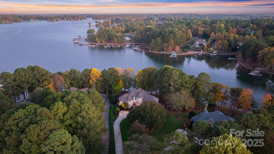 Experience the pinnacle of luxury lakefront living at this extraordinary residence in NorthView Harbour, one of Lake Norman’s most prestigious neighborhoods. Perfectly positioned on a serene cove with open water views and private beach area, this timeless custom home combines classic architectural elegance with the effortless comfort of modern design — all within a community celebrated for its premier amenities and refined lifestyle.

From the moment you arrive, the home’s stately façade, manicured landscaping, and private drive create a sense of arrival that sets the tone for what lies beyond. Inside, natural light cascades through soaring windows, illuminating rich hardwoods, elegant millwork, and finely curated finishes that speak to uncompromising quality.

The main level is anchored by an expansive great room with a wall of glass framing panoramic lake views and a fireplace that brings warmth and intimacy to the space. The gourmet kitchen is a chef’s delight — featuring custom cabinetry, professional-grade appliances, double ovens, and an oversized island perfect for casual dining and entertaining. A seamless flow connects the kitchen to formal and informal dining areas, each capturing glimpses of the shimmering water beyond.

The primary suite is a sanctuary unto itself — private, peaceful, and perfectly appointed with a spa-inspired bath, dual vanities, and tranquil lake views. The home’s dynamic floor plan continues with gracious guest suites, elegant living areas, and an abundance of flexible spaces for work, wellness, or leisure.

The lower level transforms the home into an entertainer’s paradise. Here, a full bar with wine storage complements the billiards and recreation area, while a private theater room, fitness studio, and two guest quarters provide every luxury imaginable. French doors lead to an expansive stone terrace where a custom outdoor fireplace and built-in grill await evenings spent under the stars.

A gentle slope leads to your private covered dock and boat slip, offering effortless access to Lake Norman’s endless recreation and natural beauty. Every detail — from the outdoor living spaces to the home’s immaculate condition — reflects the care and craftsmanship of a property that has been lightly lived in and lovingly maintained.

Residing in NorthView Harbour means access to an unparalleled amenity package, including a resort-style pool, elegant clubhouse, pickleball and tennis courts, walking trails, and a private boat launch — all within a gated setting of tranquility and prestige.

A home of rare quality and distinction, this waterfront masterpiece offers the opportunity to live where luxury meets leisure, and where every sunrise over the water feels like a private invitation to relax, recharge, and reconnect.