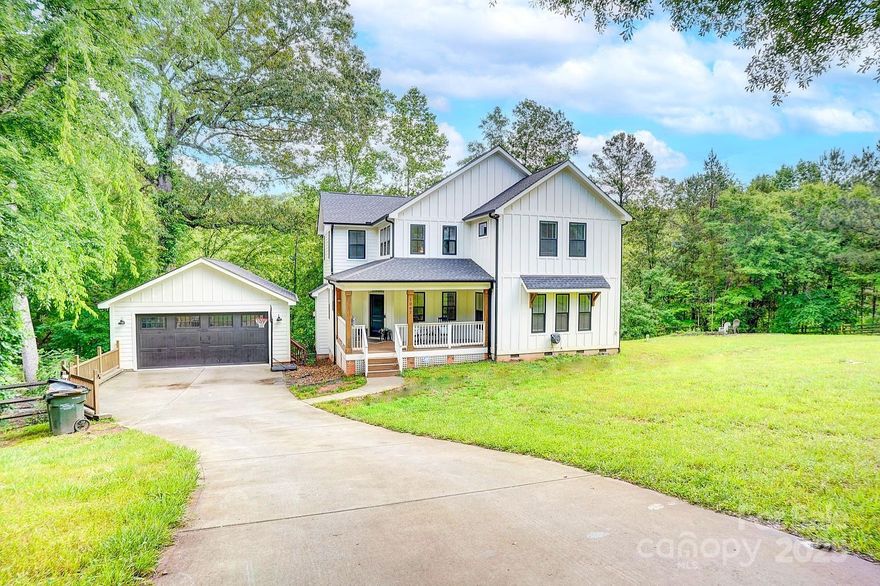 Stunning farmhouse on 1.2 acres with NO HOA! This beautifully crafted home features board and batten and Hardy plank siding. 2,808 square feet of thoughtfully designed space, including 5 bedrooms and 3.5 bathrooms. The primary suite is located on the main level, complete with an en-suite bathroom. Custom kitchen showcasing quartz countertops, stainless steel appliances, an island, and LVP throughout. The spacious living room is enhanced by wood beam ceilings and a cozy gas log fireplace, while an additional half bath downstairs provides added convenience for guests. Upstairs features a second master suite, 3 additional bedrooms, Jack-and-Jill bathroom, and an office nook. The laundry room comes equipped with a washer and dryer that remain with the home. Fully fenced-in yard, a covered front porch, and a back deck perfect for relaxing or entertaining. The pond is fully stocked and includes a dock and nearby fire pit, creating the ideal outdoor retreat with a detached two-car garage.