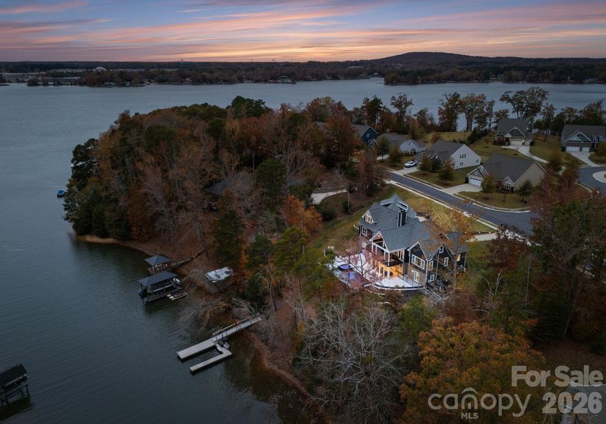 Absolutely stunning waterfront retreat on Lake Wylie! Situated on just over an acre within the desireable Palisades area with no HOA restrictions, this exceptional 6 bedroom, 5 full/2 half bath property offers unmatched freedom and luxury in one of Charlotte's most coveted locations. A charming rocking chair front porch welcomes you into a breathtaking 2-story great room, highlighted by a dramatic three sided floor-to-ceiling stone fireplace. The open dining area flows seamlessly into the chef's kitchen, featuring an oversized island with breakfast bar, 36" gas cooktop, double wall ovens and a full size side by side refrigerator and freezer. Just off the great room, the covered deck provides one of many inviting outdoor living spaces with tranquil lake views. The main level primary suite impresses with a spacious 17x21 bedroom overlooking the water, along with spa-inspired bath and walk-in closet. Two additional bedrooms, a jack and jill bath, walk-in pantry and a large laundry room leading to the 3-car garage complete the main level. Upstairs, you'll find a full private apartment  -- ideal for in-laws, guests, and more -- offering a beautiful kitchen, open living area with lake views, a generous bedroom, 1.5 baths, pantry and laundry. The expansive basement adds even more versatility featuring a living room/rec room, full kitchen, 2 bedrooms and 2 full baths. Over 1,000 sf of unfinished space offers endless possibilities for storage, home gym or future expansion. A separate one-car garage with workshop is perfect for a golf cart, tools and lake toys. Walk out from the basement to a spacious screened porch overlooking the inground pool, hot tub, grill station, built-in firepit and, of course, Lake Wylie. Follow the gentle path down to your private dock and enjoy boating, water sports, fishing or peaceful sunset views. This unique property offers true lake living with unmatched convenience. Schedule your appointment to see this incredible property today!