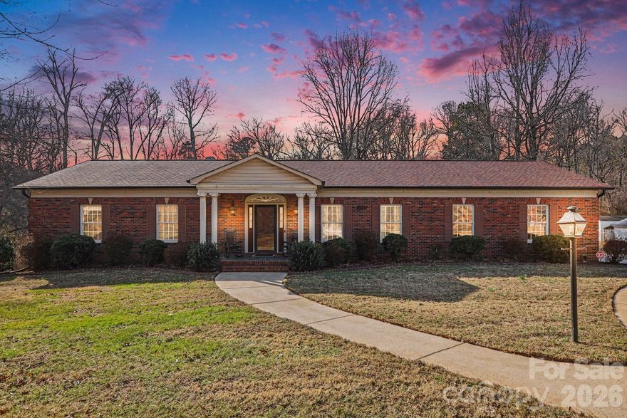 Full brick ranch nestled on a spacious, mature 1.3-acre lot along Old Salisbury–Concord Road in Cabarrus County. NO city taxes!! Enjoy the best of both worlds, peaceful country living with the convenience of nearby shopping and dining. This well-maintained home offers timeless curb appeal with a slate rocking-chair front porch, circular drive, and established landscaping that sets a welcoming tone from the moment you arrive.

Inside, generous living spaces and classic details create a warm, inviting atmosphere. The den features rich solid walnut paneling, while the lovely kitchen boasts an abundance of solid cherry custom cabinetry that flows seamlessly into the breakfast nook with matching built-ins. Yes—this home proudly offers both a traditional formal dining room and a parlor just off the front foyer, perfect for entertaining or everyday elegance.

The primary suite includes a spacious bath with dual vanities, a separate tub, and a separate shower. The thoughtfully designed layout balances comfort and functionality throughout the home.

Downstairs, a full unfinished basement offers endless possibilities—workshop, recreation space, storage, or future expansion. Outdoor living is just as appealing, with a wooden deck ideal for gatherings and a concrete patio at the basement level, an ideal spot for a porch swing where you can relax while watching birds and deer in your own backyard.

A detached shed with electric service sits on an extended concrete slab, adding even more utility. This home has been carefully cared for—clean, solidly constructed, and is move-in ready—while still offering an excellent opportunity for updates at the buyer’s discretion.

The propane tank for the two fireplaces was removed several years ago. Both fireplaces were fully operational at that time but rarely used. Seller makes no representation regarding current functionality.