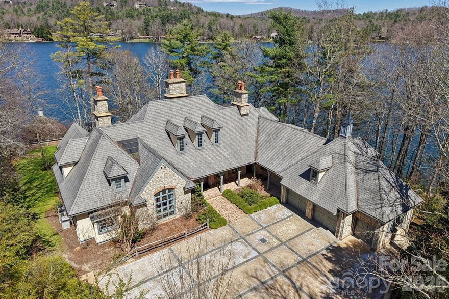 One of Lake Toxaway and Western North Carolina’s most magnificent legacy homes, this masterfully crafted 4BR, 5.5BA estate is situated on two prime lakefront point lots with 326 feet of lake frontage on fabled Lake Toxaway.  Situated very close to the Lake Toxaway Country Club, Greystone Inn, Marina, and all amenities Lake Toxaway offers, this Old World Estate offers the finest appointments including extensive stone work, large, spacious rooms, three wood burning masonry fireplaces, chef’s kitchen, expansive master suite with en-suite paneled library, gracious guest suites upstairs, bonus room with full bath over a two car garage, generator, golf cart garage, extensive outdoor entertaining spaces including a covered dining porch, firepit, large stationary dock, two stall boat house, and one of the most spectacular lake and mountain views in the mountains of North Carolina.  This home is a rare opportunity and a must see.