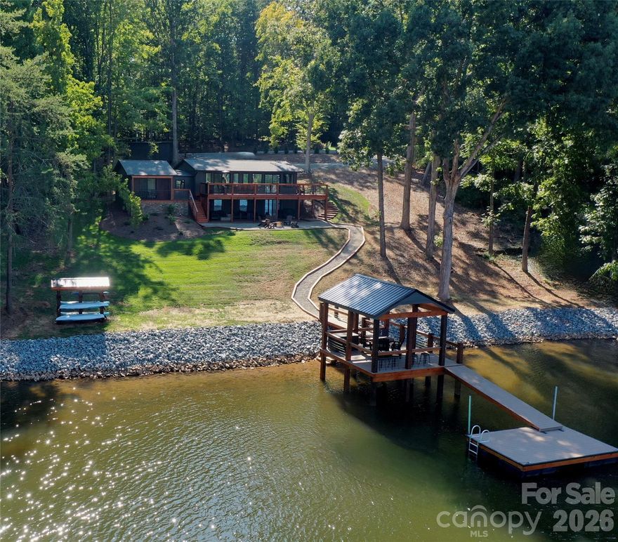 Come discover your peaceful haven away from the world. This 3 Bedroom/3 Bathroom Fully Furnished Lake Norman Home has been COMPLETELY Remodeled. This is one of the coziest homes in the Mooresville area, located right in the middle of everything, yet its private road and calm water year round gives it ultimate privacy. Experience sun and serenity  on the large open top deck, but should it rain, head below the deck to a completely covered patio. This home is an entertainers dream. Private drive in with a wrap around driveway. Open kitchen, dining, and living room. Walk down to the large basement, with additional separate entrance, perfect for hosting, for guests, a mother in law suite, or whatever you may desire. Walk outside to the fire pit/seating area overlooking the tranquil water with the New Covered Dock, finished in June 2023. A truly remarkable, standout property. A must see.