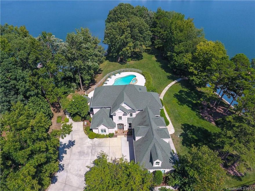 Waterfront 1.29 acres point lot w/panoramic water views and over 625 ft. of shoreline & gorgeous landscape at this premier Lake Norman home in Cornelius. This custom-built lake home features a pool,spa, & pool house,expansive terrace, private dock with seawall and rip rap & breathtaking lake views from every room. Classic style & open design enhances main level living with Master Suite on main, (2) fireplaces & built-in cabinetry. Upper level boasts 4 spacious Bedrooms, Media, Bonus room & Loft.