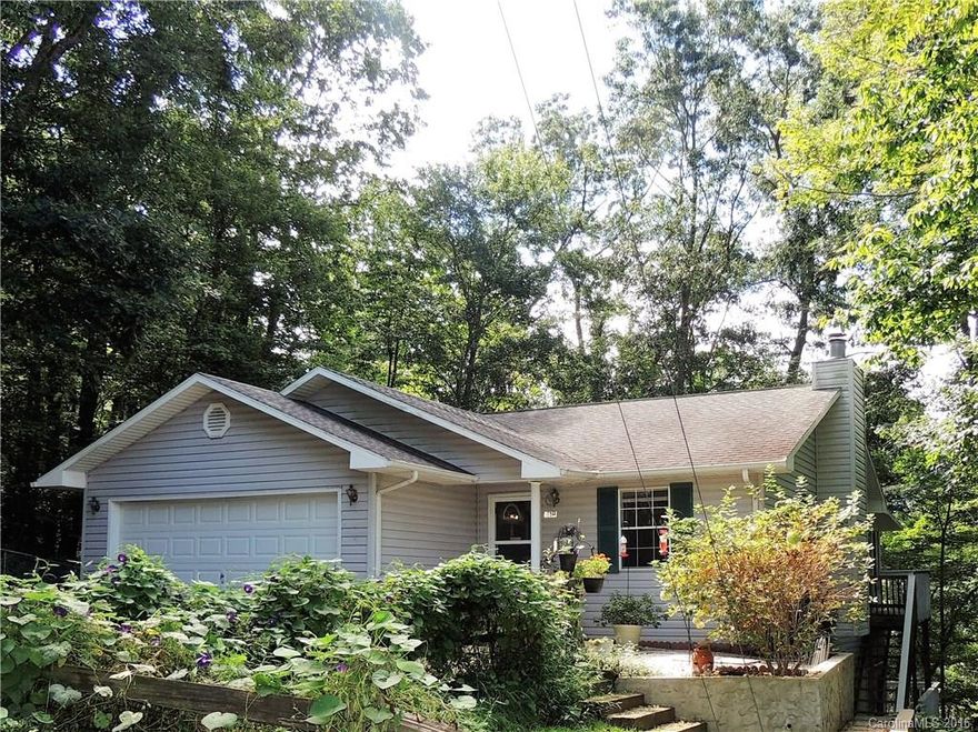 Enjoy mountain living in this charming house with spacious daylight basement.  Located and convenient to all the great restaurants and shops Black Mountain has to offer!  Enjoy the wooded views from the sun room/deck on the main level, or separate spacious open deck and screened in porch on the lower day-light basement area of the home.  2-car garage and fenced in back yard.  Master bedroom on main level.  Cozy fireplace in living room!  Home Warranty!