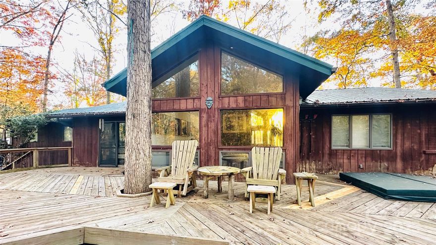 Back on market through no fault of the seller… Tucked away on over half an acre, this 3-bedroom, 2-bath home feels more like a Blue Ridge getaway than a city address. Inside, a wide-open living area with plenty of natural sunlight from floor to ceiling windows, wraps around a cozy fireplace that divides the living and dining spaces.

Step outside and it’s pure magic. A sprawling deck with a sunken hot tub overlooks your private, wooded retreat. Enjoy handcrafted wooden swings, a hammock area under the trees, a dedicated bonfire pit with its own wood shed, a powered outbuilding that has been used as a woodworking shop, and plenty of space to breathe.

Here, you’re minutes from Statesville’s conveniences, yet surrounded by the peace of your own mountain-style escape! Some other things to mention… Ivy has been planted around the exterior, creating an evergreen carpet that thrives even under the deep shade of mature trees. Traditional grass struggles to grow here because of the dense canopy and the slope of the property. Even if it did, mowing would be nearly impossible. That’s why Ivy is the perfect solution—it stays vibrant and green throughout the year, adding natural beauty to the landscape even in the heart of winter, when other plants look dormant.
The real magic lies in how the Ivy manages the massive volume of leaves that fall each autumn. Instead of endless raking or bagging, the leaves are simply left in place. The Ivy gradually pulls them down, turning them into rich, organic soil by spring. New Ivy growth conceals any remnants, ensuring the yard always looks fresh and well-kept. All that's needed is the occasional use of a leaf blower to keep pathways, the deck, and the driveway clear. No mowing, no raking—just a quick trim along the paths a few times a year.
In addition to its beauty and ease, the Ivy helps retain soil moisture and acts as a natural fire break, offering peace of mind during dry spells. For added convenience and security, the home is equipped with a professionally installed transfer switch by Energy United. Connected directly to the meter, this setup allows you to easily connect a generator to the entire house during power outages. You’ll never have to worry about losing comfort or essential functions during storms or emergencies. If you’re seeking a home with low-maintenance landscaping, year-round curb appeal, and modern utility upgrades, this property is a must-see.