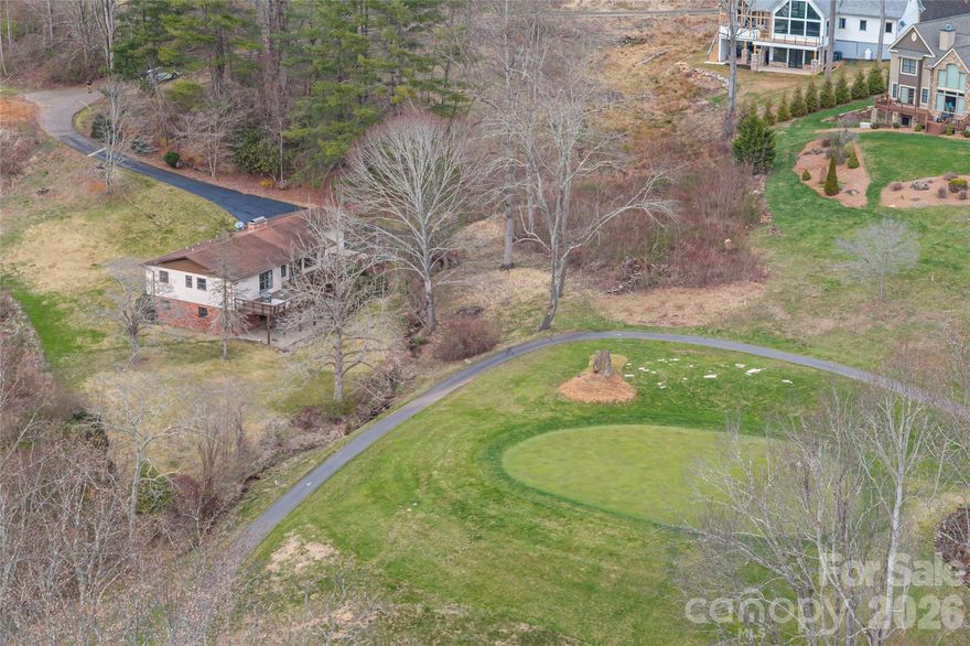 Welcome to refined mountain living inside the gated community of Springdale Estates/Country Club. Perfectly positioned on a picturesque 0.57-acre creek front lot overlooking the 17th hole, this beautifully maintained 4BR/3BA home offers 2,469 sq ft of comfort, space, and serene surroundings.

Inside, natural light fills the home, highlighting vaulted ceilings and a seamless flow between living spaces. The inviting living room features a gas fireplace and opens effortlessly into the dining area and well-appointed kitchen, complete with a skylight, modern appliances, and a gas cooktop-ideal for both everyday living and entertaining.

While the main-level provides a peaceful retreat, complemented by additional bedrooms and flexible living space to accommodate family, guests, hobbies, or a home office, it also showcases a laundry room and oversized two-car garage.

The fully finished lower level offers even more versatility with a second living area, wood burning fireplace, bonus room, workshop/storage space, and convenient walk-out access.

Outdoor living truly shines with both upper and lower decks overlooking the gently flowing creek and golf course beyond. Whether enjoying quiet mornings with coffee or unwinding at sunset, the setting creates a sense of calm that's hard to find.

Residents of Springdale enjoy access to exceptional amenities, including a championship 18-hole golf course, clubhouse, outdoor heated pool, spa, fitness center, and more (membership optional). As an added benefit, sellers are offering up to $5,000 toward the buyer's membership initiation fee, creating an opportunity to fully enjoy the country club lifestyle from day one. 

All just a short drive to downtown Canton and Waynesville, offering the perfect balance of privacy and convenience. This is an opportunity to experience mountain living at its finest - where nature, comfort, and lifestyle come together. 

Sellers also have an additional 0.43 acre lot for sale within Springdale that is ready to be built on and has already been perked for a 3 bedroom/2 bath home. MLS #4344046