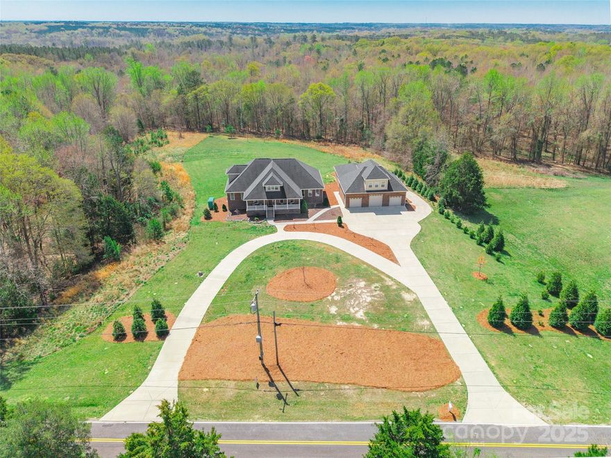 This stunning custom-built brick home sits on just over 4 acres & showcases exceptional craftsmanship with thoughtful design. Gorgeous Brazilian walnut floors add warmth & character. The beautifully designed kitchen features SS appliances, including a double oven & 5-burner gas stove, granite countertops, soft-close custom cabinets, an oversized island & walk-in pantry. Enjoy coffee on the front porch while watching the sunrise, then relax in the sunroom or on the back porch overlooking a private backyard at sunset. The attention to detail in this home is unmatched. Designed for comfort, the home includes 2 high-efficiency HVAC units, a whole-home water filtration system & a 40w Cummings generator! The 2nd living quarters above the 3-car garage includes a 1/2 bath, bonus room & workshop. Another garage provides 4 more spaces, offering a total of 7 garage spaces. Only 2 miles from I-77 & 30 mins to Charlotte. With no HOA, this private retreat is a rare find!