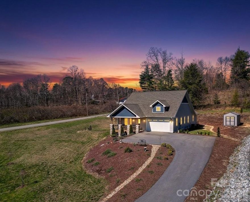 Located in the heart of Hendersonville, NC, this home offers the perfect balance of peaceful living and everyday convenience, just minutes from charming downtown, renowned apple orchards, local vineyards, shopping, dining, and top tier healthcare. Welcome to this beautifully crafted newer construction home offering space, style, and functionality. Situated on nearly an acre on a desirable corner lot, this 3 bedroom, 2 bath home features over 1800 square feet of thoughtfully designed living space and an expansive yard that’s hard to find. Inside, you’ll love the open floor plan highlighted by soaring 10 foot ceilings, 8 foot doors, and rich wood flooring that flows throughout the main living areas. The oversized kitchen island serves as the centerpiece of the home, complemented by ample cabinet space for storage and organization, making it ideal for entertaining or everyday living. The stone faced gas fireplace adds warmth and charm to the living room perfect for relaxing here in the mountains of WNC. The spacious primary suite is a true retreat, featuring double closets, a beautifully tiled walk-in shower, and a double vanity. Storage is abundant throughout the home, offering both functionality and convenience. Enjoy outdoor living year round on the oversized covered front and rear porches overlooking the large back and side yard, complete with a storage shed for tools or hobbies. The attached two car garage includes a utility sink, adding even more practicality. This home delivers modern comfort, generous space, and an unbeatable Hendersonville location, schedule your showing today!