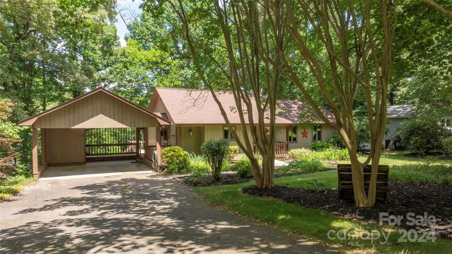 Welcome to your charming waterfront retreat on Lake Norman! This meticulously maintained 3-bedroom, 2-bathroom single-level home, originally constructed in 1981, offers the perfect blend of privacy and convenience. Situated on a lushly landscaped .57 acre lot, you’ll enter the property through a picturesque canopy of trees.
Located in the desirable town of Sherrills Ford, this home boasts close proximity to the new Publix shopping center, lakefront restaurants and marinas. This neighborhood includes a mix of new custom built homes and established older homes, all with NO HOA restrictions.  Boat enthusiasts will enjoy the oversized covered floating dock with deep water, ensuring usability year round. Experience easy access to the main channel within minutes, while still benefiting from a tucked-away location for ultimate privacy and peace. Enjoy relaxing evenings on the huge covered back porch overlooking the water. An open floor plan with vaulted ceilings await your personal touch.