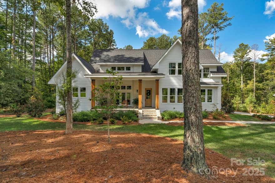 Step inside this nearly new, custom-built home in Riverchase Estates.  The sellers are offering a $25,000 credit to apply towards completing finishes to the buyer’s taste, closing costs, or a mortgage rate buy-down.

The bright white exterior is accented by warm wood columns, a stone-clad front porch with double-door entry, and sleek black modern lighting that enhances the home’s architectural appeal. Inside, the home is open, airy, and bathed in natural light. Rich wide-plank rustic wood floors—crafted from trees harvested directly from the property—set the tone throughout. 

High ceilings and custom lighting highlight the oversized great room, which offers seamless access to both the front and rear porches. The kitchen is designed for both beauty and function, featuring a large center island with butcher block countertop and bar seating, quartz countertops, a white subway tile backsplash,  five-burner gas range with hood, butler’s pantry, and an additional walk-in pantry.  The adjacent dining area completes the true open-concept layout. 

The main-level primary suite is a private retreat with wood-beamed cathedral ceilings, double doors leading to the rear patio, and peaceful wooded views. The ensuite bath includes dual furniture piece vanities, a soaking tub, and a separate tiled walk-in shower.  Also on the main level, is a private office, along with a side entry mudroom offering abundant storage, laundry, bench seating, and access to the oversized garage. 

Upstairs, a versatile loft provides space for relaxing or entertaining, along with three generously sized bedrooms. Two bedrooms share a Jack-and-Jill bath with a tub/shower combination. A convenient bonus craft closet completes the upper level. 

A standout feature of the home is the separate bonus space, offering exceptional flexibility for new owner to tailor to their needs. This space is currently designed as a second living quarters; however, as a private space, it can serve as a guest suite, private office, studio, or multi-purpose retreat. With 14-foot ceilings on the lower level and a private rear entrance, the space includes a lounge or sleeping area below and a kitchenette, dining area, and full bath upstairs.

Outdoor living features a covered rear porch showcasing a stone fireplace, multiple seating areas, and steps leading to a sprawling backyard. Mature landscaping, a dedicated garden space, and a lush tree canopy provide outstanding privacy and serenity. The outdoor space has access to a full bathroom and offers the perfect backyard for a future pool.  

Located within the amenity-rich Riverchase Estates community, residents enjoy access to a clubhouse, outdoor pool, tennis courts, playground, Catawba River access, and more. Less than a 15 minute drive to restaurants, shops and all that Indian Land has to offer.