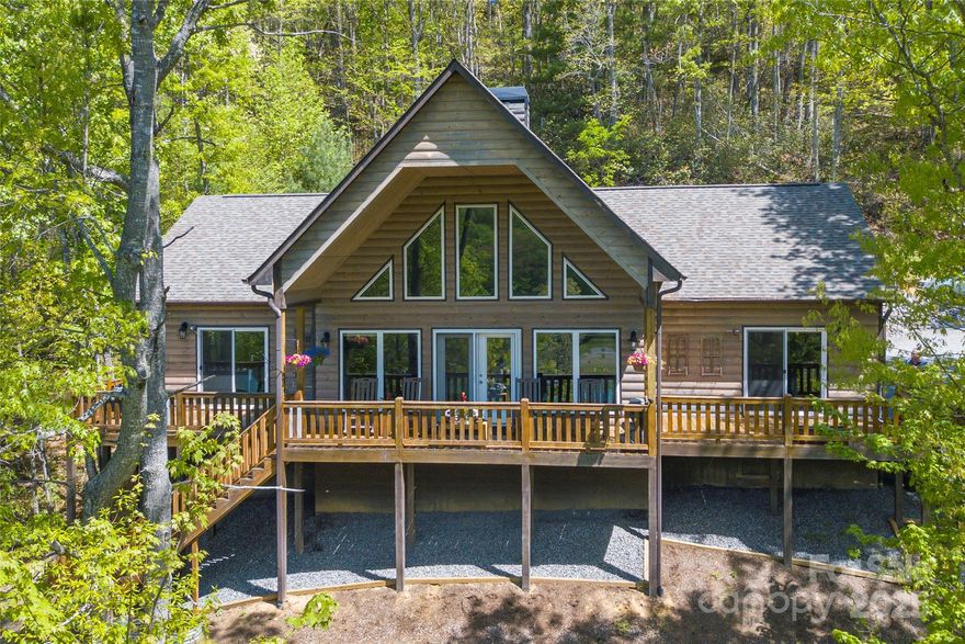 MOTIVATED SELLER! This stunning Arts and Crafts home offers effortless one-level living, an inviting open floor plan, and abundant natural light. The spacious living room boasts vaulted ceilings, a striking stone wood-burning fireplace, and expansive windows that seamlessly connect the indoors with the outdoors. Step directly onto the generous, partially covered deck. The chef’s kitchen is a delight, featuring granite countertops, ample cabinetry, and plenty of workspace. The primary suite offers an ensuite bath with double sinks, granite counters, walk-in shower, large walk-in closet, and conveniently located laundry. Enjoy minimal yard work. A dedicated workshop awaits the handyman, an oversized one-car garage adds functionality. City water, sewer, roads, and services. STRs are permitted, making this not just a dream home but a smart investment. Your perfect full-time or part-time home in an unbeatable location, less than 10 minutes from downtown, 30 minutes to Asheville.