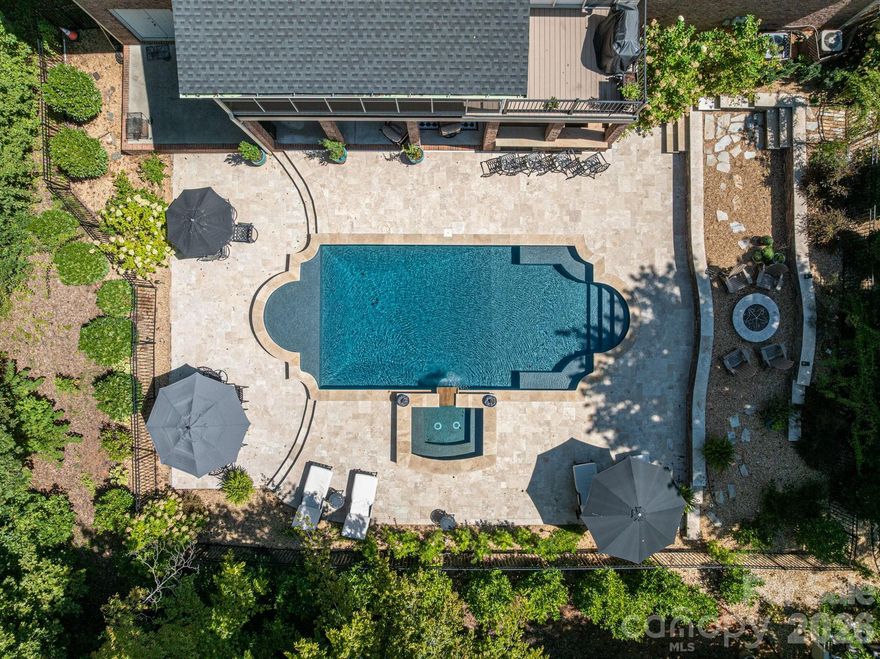 Now offered at $930,000, this exceptional home is designed for those who want space, flexibility, and privacy without giving up easy access to Charlotte. This home offers resort-style living in a peaceful country club setting and is perfectly positioned for Charlotte commuters and relocating professionals. This home offers convenient access to Uptown, major employment corridors, and CLT airport - while providing a level of space and privacy increasingly hard to find closer in. 

A bright, airy layout welcomes you inside, anchored by a gourmet kitchen ideal for entertaining and daily life alike. The fully finished walkout basement offers a second full kitchen, creating rare flexibility for multi-generational living, extended guests, private work-from-home space, or game-day hosting. Thoughtful design allows the home to flex effortlessly for work, fitness, and play.

Step outside to your private backyard oasis, complete with a heated saltwater pool and spa, outdoor kitchen, and firepit—perfect for year-round enjoyment and relaxed entertaining. Whether hosting a crowd or enjoying quiet evenings at home, the outdoor living experience rivals that of a vacation retreat.

Upstairs, the home features three additional bedrooms, each with bathroom access, along with two full baths, a bonus room, and a walk-in attic, offering abundant storage and versatility. A dedicated office, side-load garage with extra storage, and circular drive add convenience and curb appeal.

Recent updates provide peace of mind, including a new roof (2025), newer HVAC systems, updated water heater, and fresh interior paint. Professional landscaping enhances the home’s polished, move-in-ready feel.