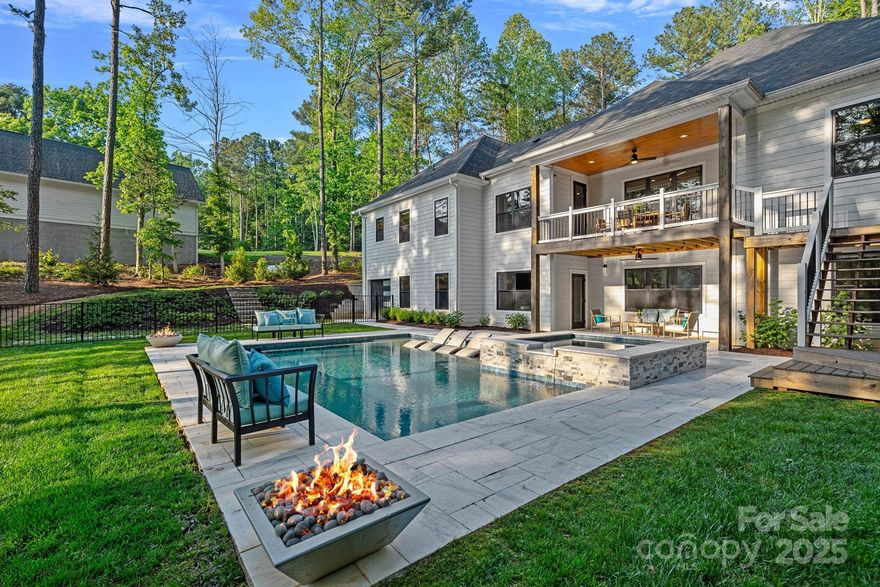 Discover modern waterfront luxury on 1.65 acres along the shores of Lake Norman in this 2022-built masterpiece. Blending contemporary elegance with timeless farmhouse charm, this home features a private pier, resort-style pool, spa, and lakeside fire pit—perfect for outdoor living. Inside, an open-concept layout showcases designer finishes, a chef’s kitchen with oversized island, and a main-level owner’s suite with spa bath plus two guest suites. Upper level guest suite with bonus area. The lake level offers a kitchenette, great room, and two flexible rooms ideal for bunk spaces or possible additional guest accommodations. This property allows short-term rentals, offering excellent investment potential. A rare opportunity for refined lakefront living.
