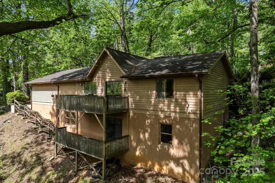 Calling all dreamers—this well-loved home is bursting with potential and ready for a fresh start! Completely livable as is, while you do updates to make it your own. Tucked away in the trees just 2 miles from downtown Tryon’s charming shops, dining, and culture, this elevated ranch offers privacy and convenience. The main level features soaring cathedral ceilings, a dramatic floor-to-ceiling fireplace, and large kitchen windows with natural light flooding in. A split bedroom layout includes three bedrooms, two full baths, and a laundry room, making for easy one-level living. Downstairs, the massive unfinished basement with tall ceilings, a brick fireplace, and an existing full bath opens the door to endless possibilities—create additional living space, a studio, or an in-law suite. A 2-car garage and generous paved driveway add practicality and ease. Bring your vision—this home has great bones and the space to become something truly special. DO NOT WALK ON THE REAR DECKS!