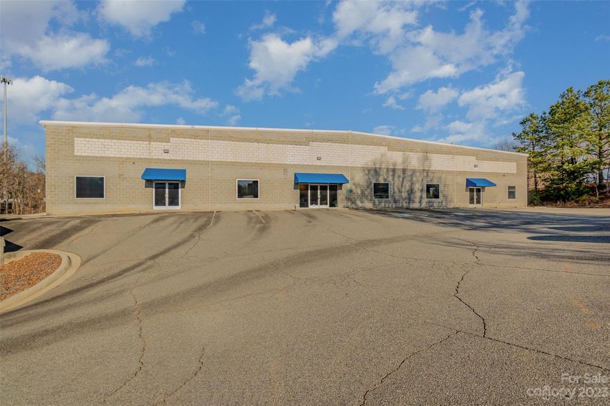 24,000 + or - sq ft warehouse/office/ light industrial space includes 6000 + or - sq ft of finished office space. Recent use by engine development company. Originally built as Lowe's vendor executive office/showroom. 4 offices presently leased month to month, with side and front entry doors, separated from main offices by removeable wall/privacy door. Tenant wishes to remain, will sign long term lease if new owner prefers. Right side of warehouse previously leased, presently divided by fencing (now open, with gate included) & includes roughed in entry, office space, 2 bathrooms. Easy conversion to one user or keep space as-is for multiple tenants. 5 gas furnaces in main shop area. One 25 ton A/C in  main shop work area (480 volts). 4 A/C and electric heat units in offices. Updated bi-annual service contracts with Trane. Loading- 4 dock high doors and 2 12 x 14 grade level doors. Air compressor included. Office includes built-ins, conference table, 20+ executive chairs, desks. 7 baths.