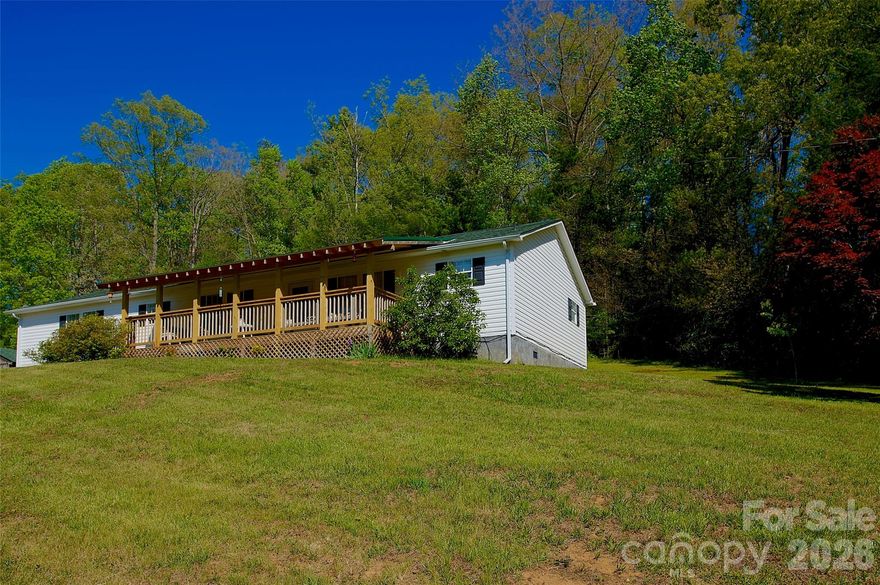 6.04 unrestricted, developable acres offering endless opportunity & income potential. Well-maintained 1999 3BR/3BA on-frame modular home (1,952 sq ft) features private well, city sewer, open floor plan, expansive living areas, grand master suite w/ dual full baths, huge walk-thru closet, gas logs, island cooktop, ample cabinets/counter space, central HVAC, large covered porch w/ mountain views, adjacent carport & utility building.
Recent updates: Roof (2020), well pump (2024), garage doors & front door (2025).
Key outbuildings & features:

1,440 sq ft (30ft. X 48ft.) fully insulated master workshop (engineered metal bldg by New Horizon, 150 mph wind-rated, industrial epoxy floor w/ expansion joints on 5,000 PSI concrete, (2) 10x8 ft doors opposite sides, 200A service, water/sewer hookups ready, interior bath & sink plumbing installed)
1,008 sq ft additional building (convertible to home)
Separately metered lot for camper/single-wide (income potential)
Large chicken coop/run & poultry cage; additional pen section ready to assemble
Old dynamite/survival bunker (ideal for cellar/storage)
Fruit trees, ample space for gardens/expansion

Private gravel drive leads to secluded mountain setting just outside Spruce Pine, NC—1 mile to Blue Ridge Parkway.
Prime location for mountain living:

1 min to BRP
3 min to downtown Spruce Pine, Blue Ridge Regional Hospital, new state-of-the-art gym/indoor pools
5 min to Walmart Supercenter
6 min to Grassy Creek Golf & Country Club
8 min to Penland School of Crafts
10 min to Linville Falls Winery
15 min to Burnsville
20 min to Grandfather Mountain State Park or Linville Falls
30 min to Lake James (fishing/water sports), Marion shopping, I-40
30 min to Banner Elk, Beech Mountain, Sugar Mountain (skiing, fine dining, Mountain Glen GC)
50 min to Asheville
60 min to Johnson City, TN & Tri-Cities Airport
2 hrs to Charlotte

Perfect for mini-farm, multi-unit rentals, vacation/retirement retreat, hobbyists/toy storage, or outdoor enthusiasts. Enjoy scenic daily drives, world-class mountain beauty, recreation, and welcoming communities!