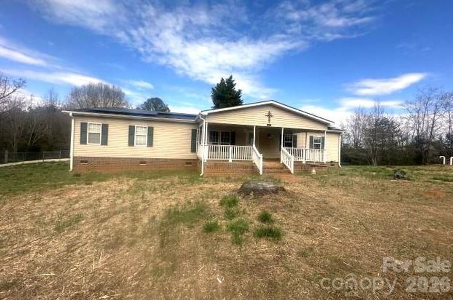 Spacious double-wide manufactured home situated on 0.68 acres, offering peaceful country living with room to spread out. This 3-bedroom, 2-bath home features a welcoming covered front porch, perfect for relaxing and enjoying the outdoors. Inside, you’ll find a large living room with a stone fireplace and gas logs, creating a cozy gathering space. The home offers a generous kitchen with ample cabinet and counter space, along with a dining area ideal for everyday living. The primary suite includes a walk-in closet and private bath with double vanity and soaking tub. Enjoy the added benefit of a fenced yard, providing space for outdoor activities, pets, or gardening. Conveniently located near Gaffney amenities, shopping, dining, and easy access to I-85. A great opportunity for buyers looking for space, comfort, and country charm.