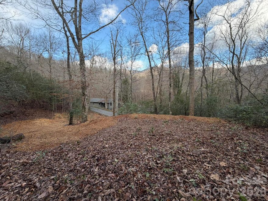 Charming wooded lot with seasonal views! The lot is pre-cleared and marked for ease of viewing; ready for building. Located in the picturesque town of Franklin, NC within the robust Golf Course community of Mill Creek.  This property is an easy location, less than one minute driving from Mill Creek's front gate. Conveniently located 10 minutes to downtown Franklin, local amenities, and the primary commercial areas. Lot is large enough for a one-story ranch for easy living and plenty of room for parking. Enjoy the serene surroundings from your personal forested oasis. Community access to town water and sewage will save you thousands.  This land is a fantastic opportunity for those seeking tranquility and comfort. This community is zoned for the excellent Cartoogechaye Elementary School.