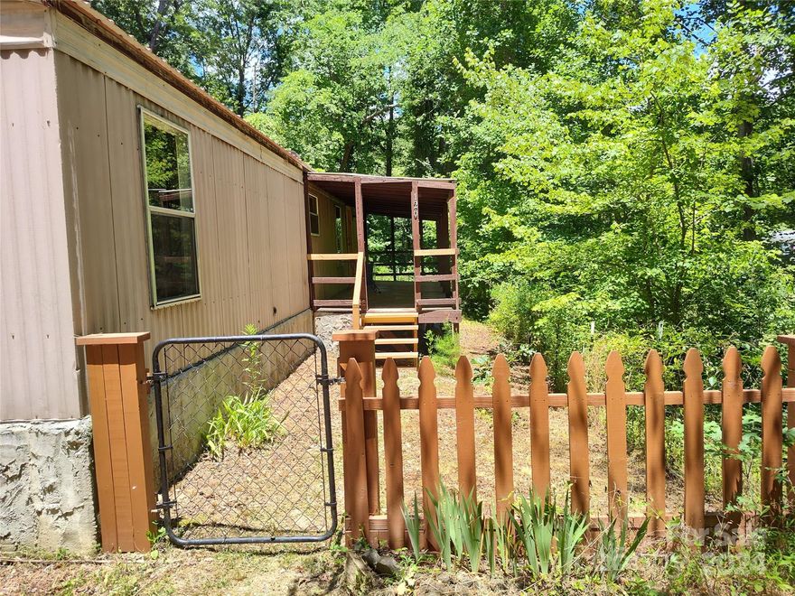 Discover this very private and cozy home only 10 minutes to Asheville and 5 minutes to the French Broad River. Surrounded by the natural beauty of the woods, birds and frequent deer. Wild raspberries growing near a fenced in dog yard. Enjoy watching fireflies from the covered front porch. Home manufactured in 1993, Cedar-wood brand. New metal roof in 2020, new electrical panel 2024. Needs some TLC, waiting for a handyman to make it shine! Adjacent .68 acre property for sale with level spot for building, with a garage on slab.
.