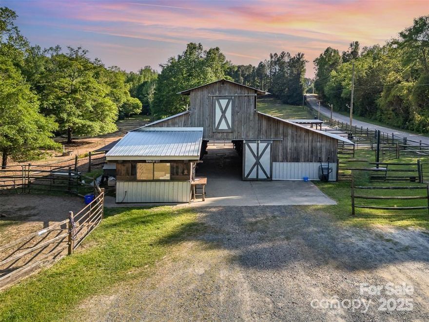 This exceptional 11.57-acre equestrian property offers a rare opportunity to enjoy the privacy and tranquility of country living, all while being just minutes from the conveniences and amenities of Indian Land. The main barn has been completely redone throughout the years, which includes includes 18 horse stalls (made up of 2 box and 16 standing stalls), each equipped with individual lighting. Attached to the barn are a functional tack room and a temperature controlled feed room with hot water, providing convenience for daily operations. Equestrian amenities include lighted riding arena that allow for evening or night training, and water lines run to three separate pastures, supporting efficient care and grazing for horses. Also included are 2 paddocks, a round pen, shop/equipment building, and spectator seating! On the opposite side of the street, a separate hay barn is included as part of the property, offering additional space for feed storage and equipment. The facility has been successfully run for years as a riding school and summer camp, and is perfectly suited for continued use as a boarding stable, training center, or equestrian camp OR working farm. A one-story brick home with a fully finished basement is located on the property and is included in the sale in as-is condition. With excellent infrastructure, a strong reputation, and income-generating potential, this is the perfect opportunity for any horse enthusiast or entrepreneur!